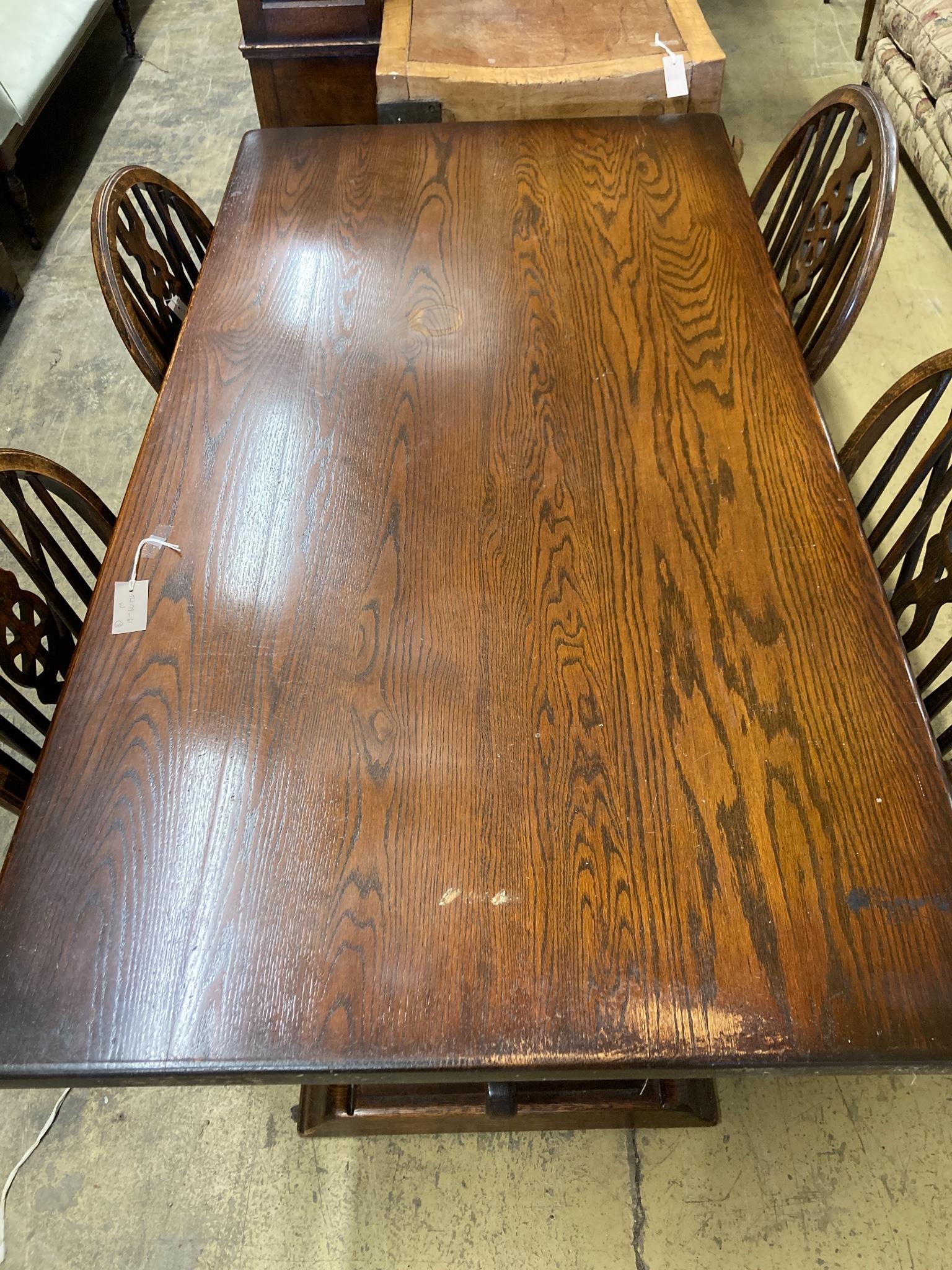A 17th century style oak 'refectory' table on shaped trestle end supports, length 160cm, depth 83cm, height 75cm and four wheelback Windsor chairs